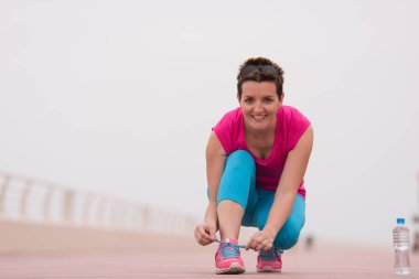 genç kadın üzerinde spor ayakkabı ayakkabı bağcığı bağlama