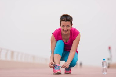 genç kadın üzerinde spor ayakkabı ayakkabı bağcığı bağlama