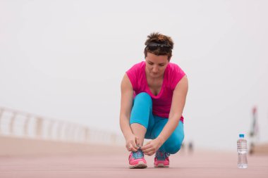 genç kadın üzerinde spor ayakkabı ayakkabı bağcığı bağlama