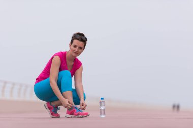 genç kadın üzerinde spor ayakkabı ayakkabı bağcığı bağlama