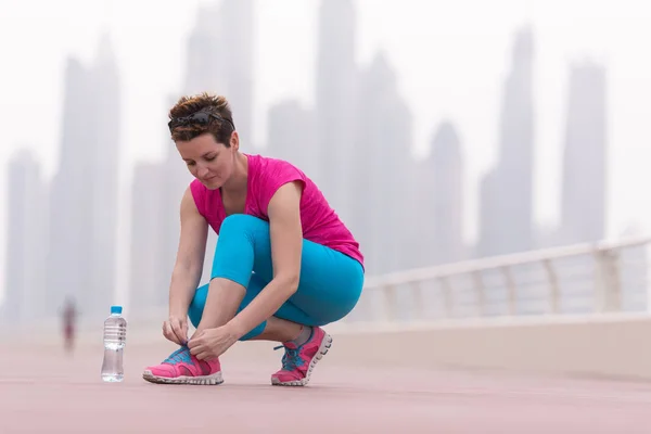 Woman tying shoelaces on sneakers — Stock Photo, Image