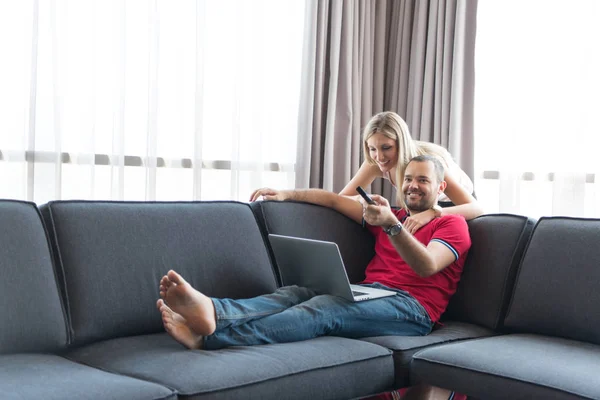 Šťastný pár se uvolňuje v obývacím pokoji — Stock fotografie