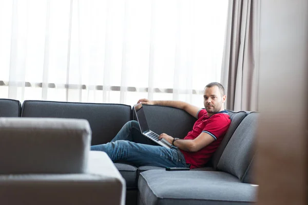 Seorang pria menggunakan laptop di ruang tamu — Stok Foto