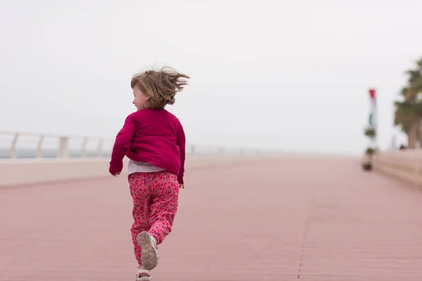 Cute little girl on the promenade by the sea — Stock Photo, Image