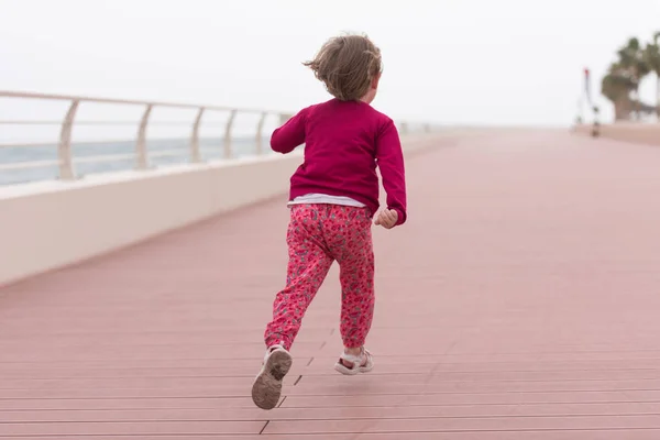 Roztomilá holčička na promenádě u moře — Stock fotografie