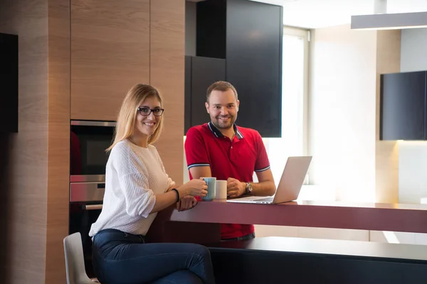 Par dricka kaffe och använder bärbar dator hemma — Stockfoto