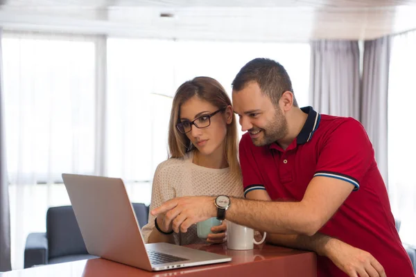 Casal beber café e usando laptop em casa — Fotografia de Stock