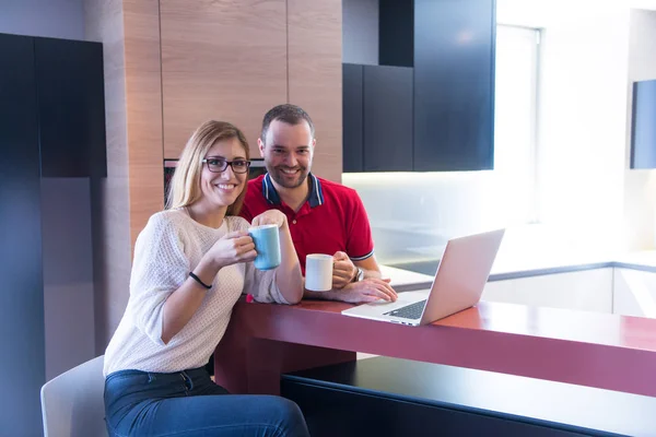 Ζευγάρι, πίνοντας καφέ και να χρησιμοποιούν φορητό υπολογιστή στο σπίτι — Φωτογραφία Αρχείου