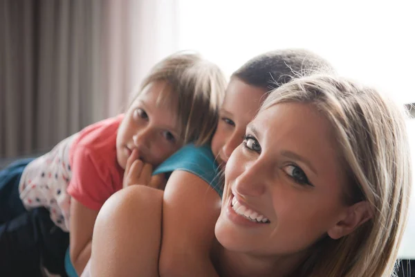 Jonge moeder tijd doorbrengen met de kinderen op de verdieping — Stockfoto