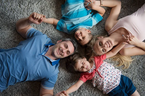 Famille heureuse couchée sur le sol — Photo