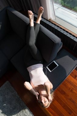 Çok güzel sarışın kadın için koltukta istirahat ederken müzik dinlemek