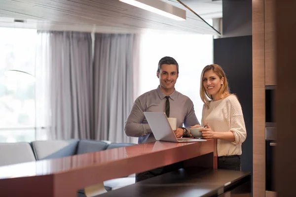 Una giovane coppia si prepara per un lavoro e utilizza un computer portatile — Foto Stock