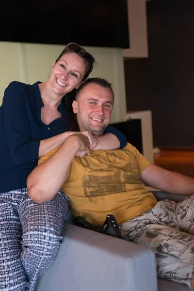 Young handsome couple hugging on the sofa — Stock Photo, Image