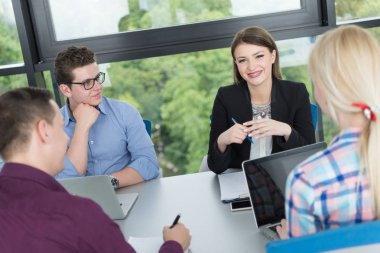 Bir grup iş adamı ofiste iş planlarını tartışıyor.