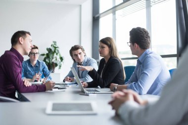 Bir grup iş adamı ofiste iş planlarını tartışıyor.