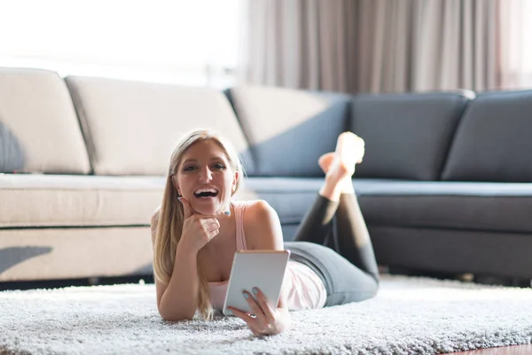 Ung kvinna med Tablet PC-datorn på golvet — Stockfoto