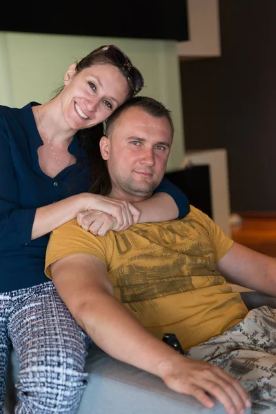 Young handsome couple hugging on the sofa — Stock Photo, Image