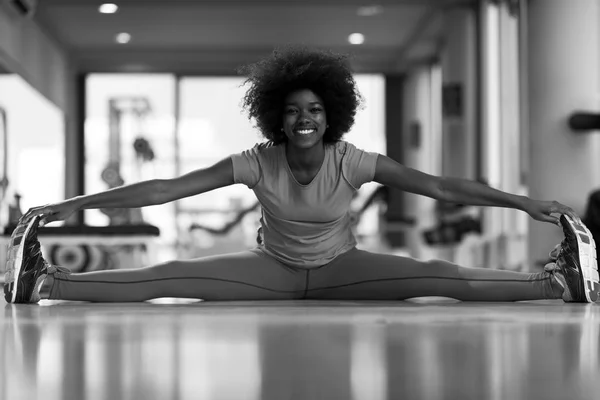 Mulher em um ginásio alongamento e aquecimento antes do treino — Fotografia de Stock