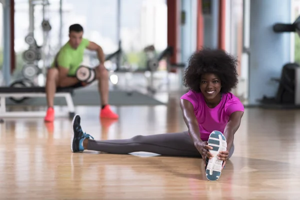 Kvinna i ett gym stretching och värmer upp — Stockfoto