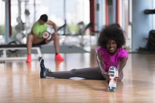 Frau im Fitnessstudio dehnt sich und wärmt sich auf — Stockfoto