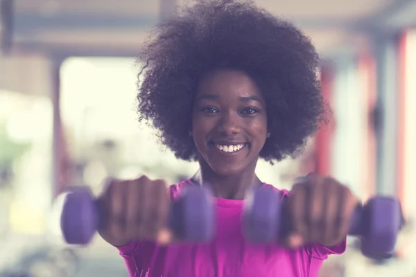 Woman working out in a crossfit gym with dumbbells — Stock Photo, Image