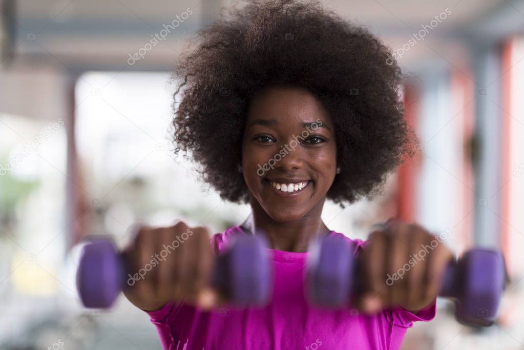 woman working out in a crossfit gym with dumbbells