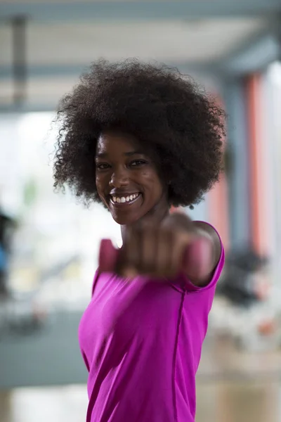 Donna che lavora in una palestra crossfit con manubri — Foto Stock