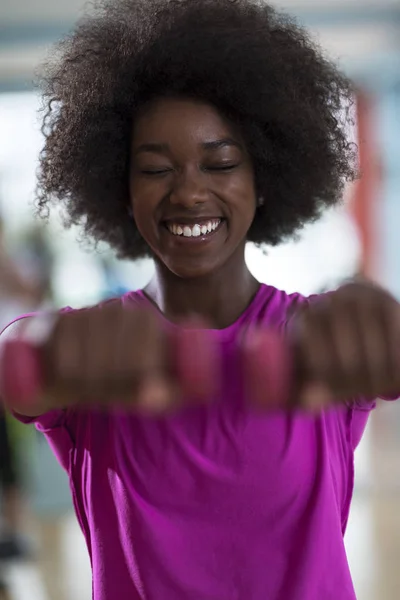 Mulher trabalhando em um ginásio crossfit com halteres — Fotografia de Stock