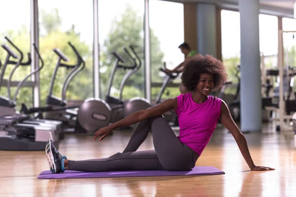 Afroamerikanska kvinnan utöva yoga i gymmet — Stockfoto