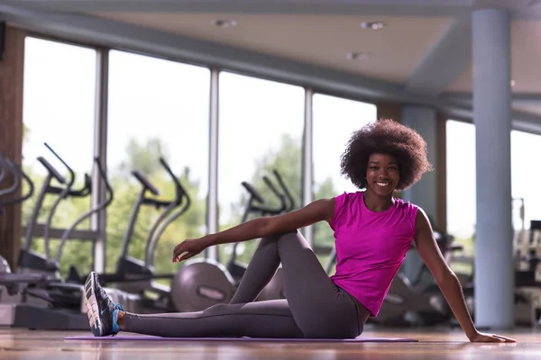 Afroamerikanska kvinnan utöva yoga i gymmet — Stockfoto