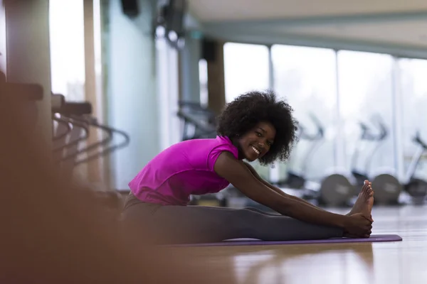 Afroamerikanska kvinnan utöva yoga i gymmet — Stockfoto