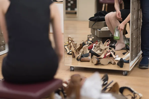 Женщина сидит в обувном магазине — стоковое фото