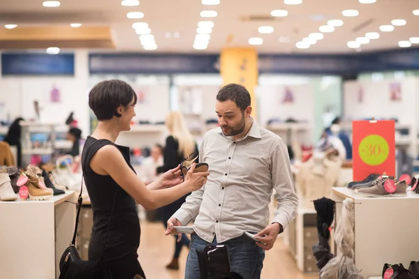 Paar kiest schoenen bij schoenenwinkel — Stockfoto