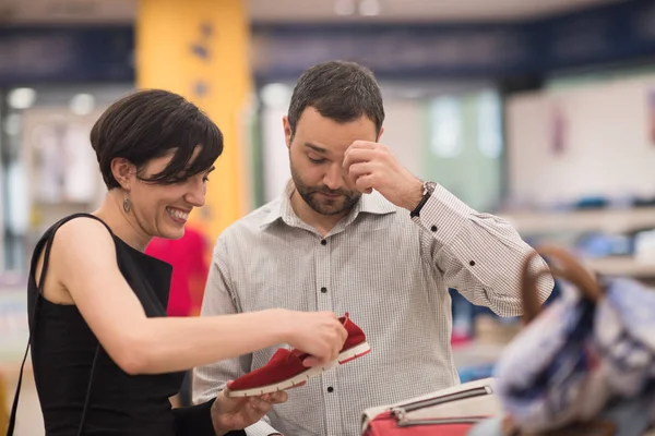 Paar kiest schoenen bij schoenenwinkel — Stockfoto