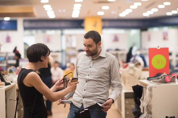 Paar kiest schoenen bij schoenenwinkel — Stockfoto