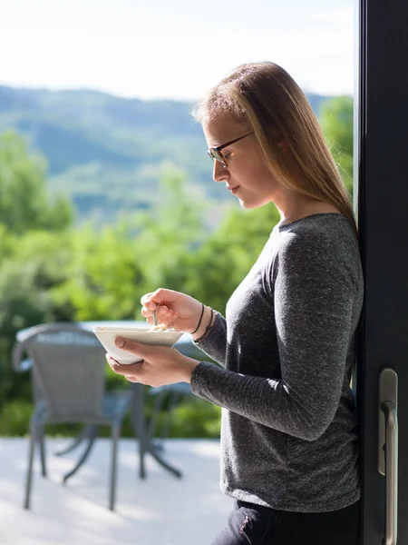 Kvinna som äter frukost framför hennes lyxhus — Stockfoto