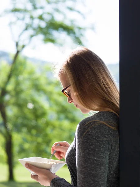 Woman eating breakfast in front of her luxury home — Stock Photo, Image