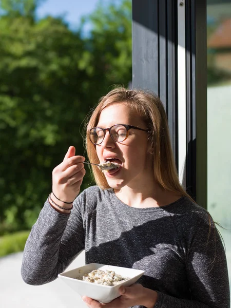 Kvinna som äter frukost framför hennes lyxhus — Stockfoto