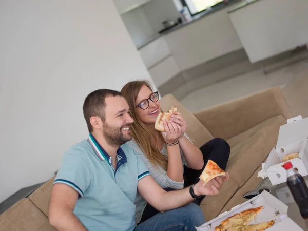 Casal comer pizza em sua casa de luxo — Fotografia de Stock
