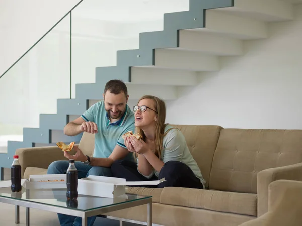 Casal comer pizza em sua casa de luxo — Fotografia de Stock