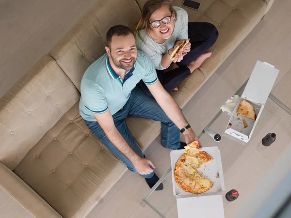 Casal comer pizza em sua casa de luxo — Fotografia de Stock