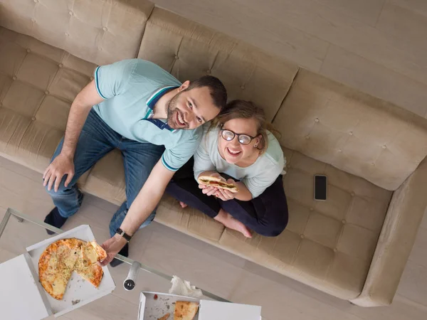 Casal comer pizza em sua casa de luxo — Fotografia de Stock