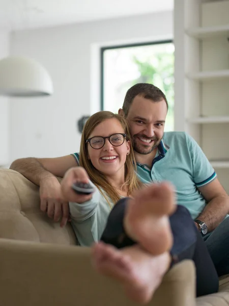 Jovem casal no sofá assistindo televisão — Fotografia de Stock