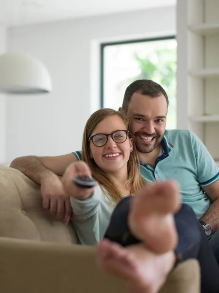 Jovem casal no sofá assistindo televisão — Fotografia de Stock