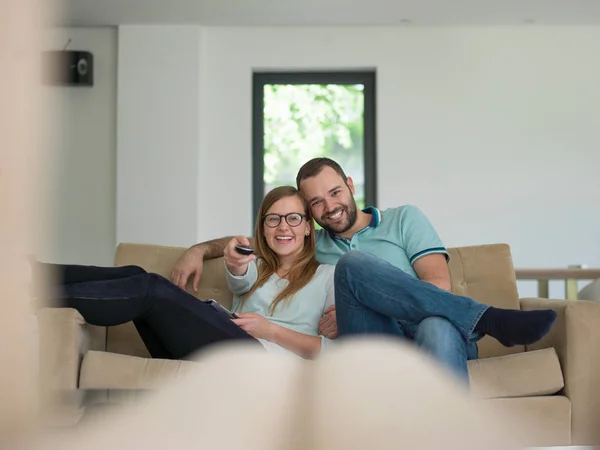 Jong (echt) paar op de bank tv-kijken — Stockfoto