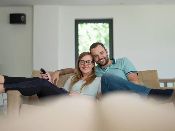 Jong (echt) paar op de bank tv-kijken — Stockfoto