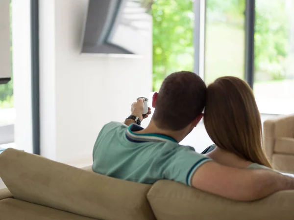 Jong (echt) paar op de bank tv-kijken — Stockfoto