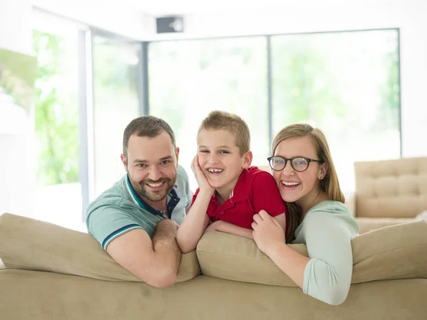 Семья с маленьким мальчиком наслаждается в современной гостиной — стоковое фото