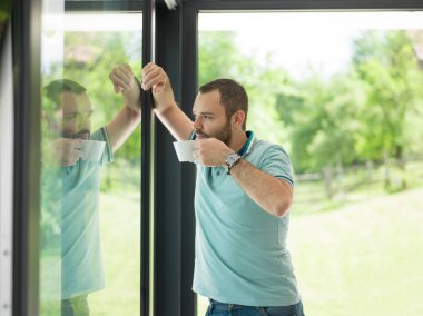 pencerenin yanında içme sabah kahvesi genç adam