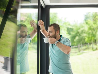 pencerenin yanında içme sabah kahvesi genç adam